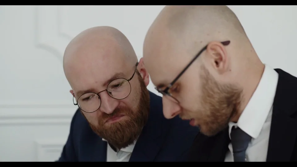Original video frame with two people and a room background
